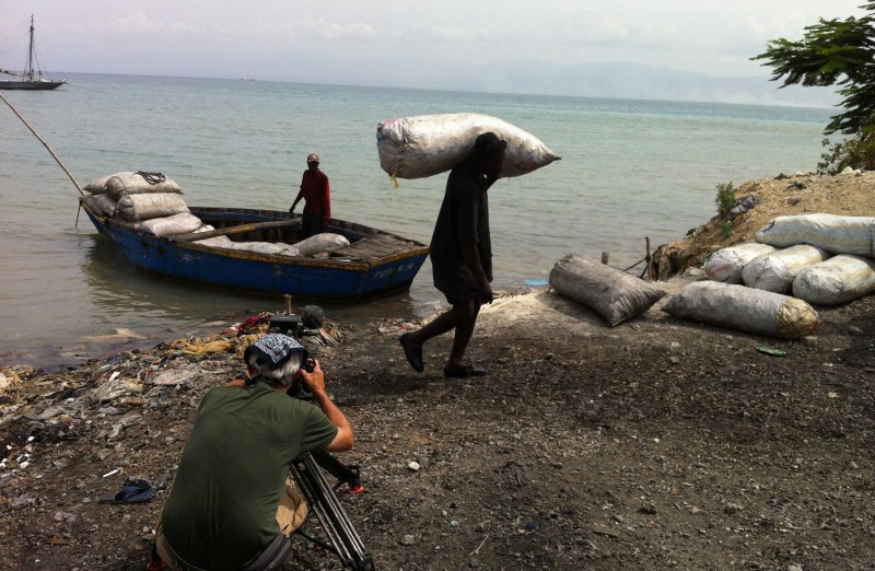 Charcoal port, Port au Prince, Haiti. Worker unloads sacks of charcoal.